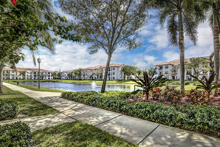 Greystar Avana Isles Community Exterior Shot with Lush Green Space and a Walkway